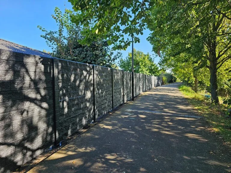 Langer Betonzaun entlang eines Grundstücks
